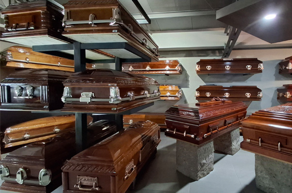 Variedad de ataúdes de madera y urnas para servicios funerarios.