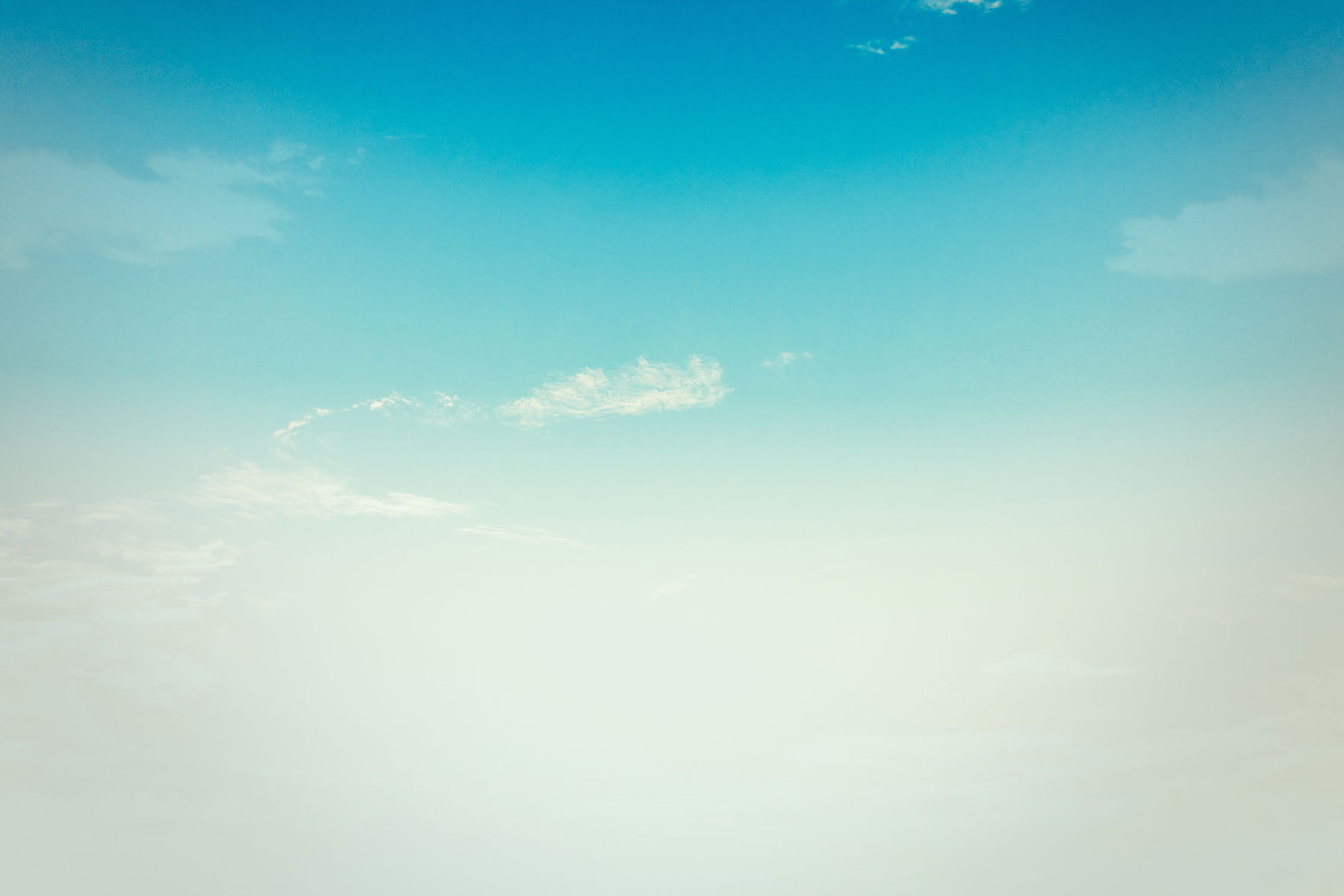 Cielo azul que se va degradando a tonos blancos algunas nubes blancas.