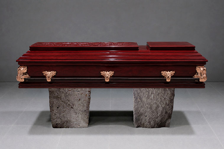 Ataúd de madera de lujo con asas de metal.