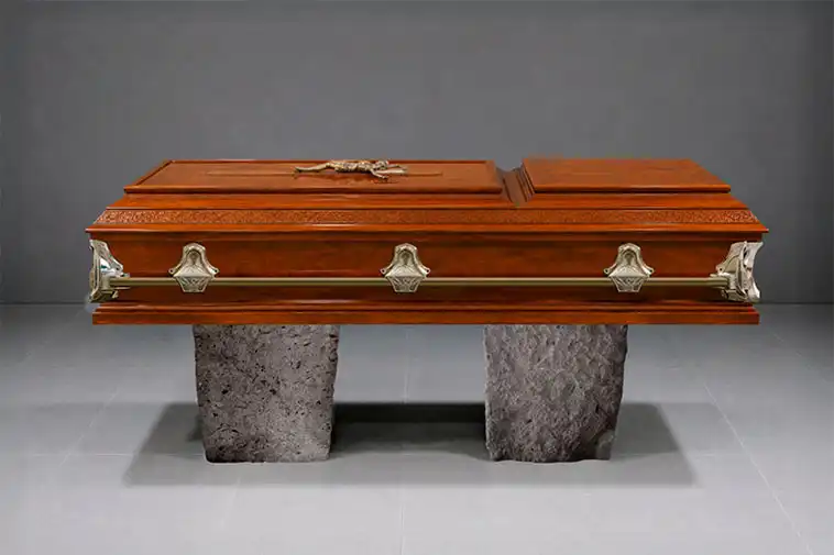 Vista lateral de ataúd de madera con acabado elegante y manijas de metal, incluido en el servicio funerario Preferente de Funeraria Valparaíso.