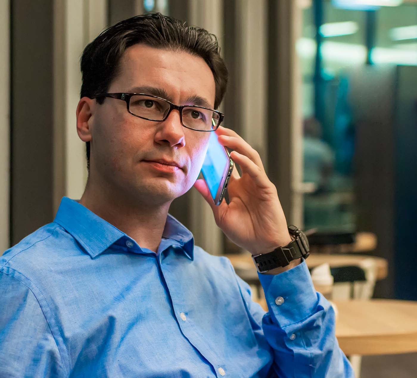 Hombre adulto llamando por teléfono con apariencia seria.