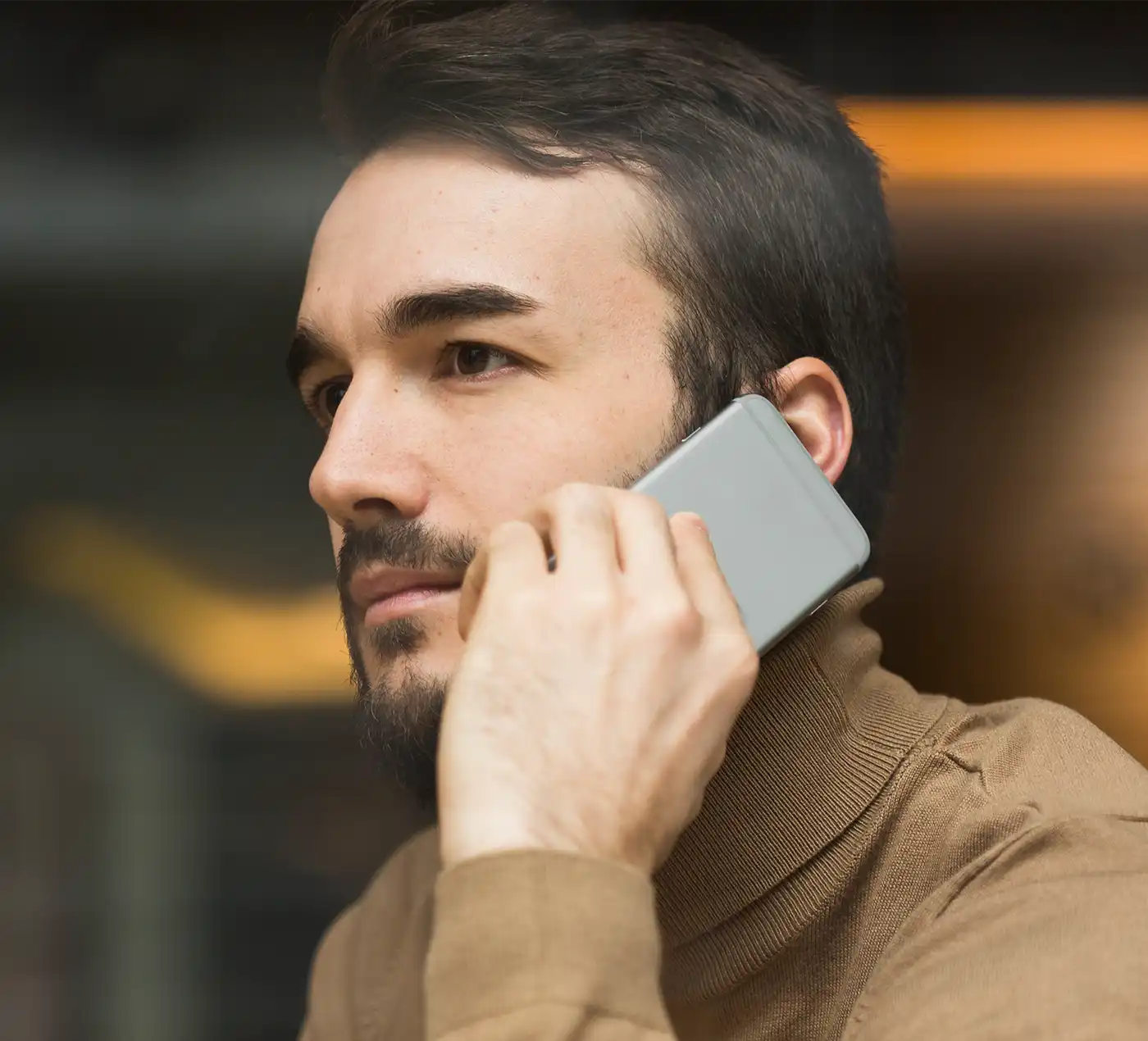 Hombre adulto llamando por teléfono con apariencia seria.