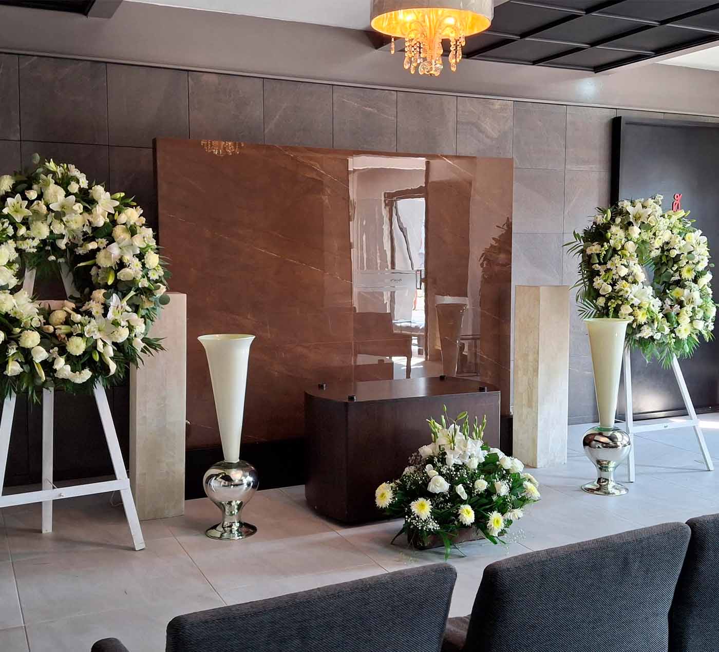 Instalaciones de la funeraria Valparaíso, donde se encuentra una sala preparada con flores y velas para rendir un homenaje funerario.