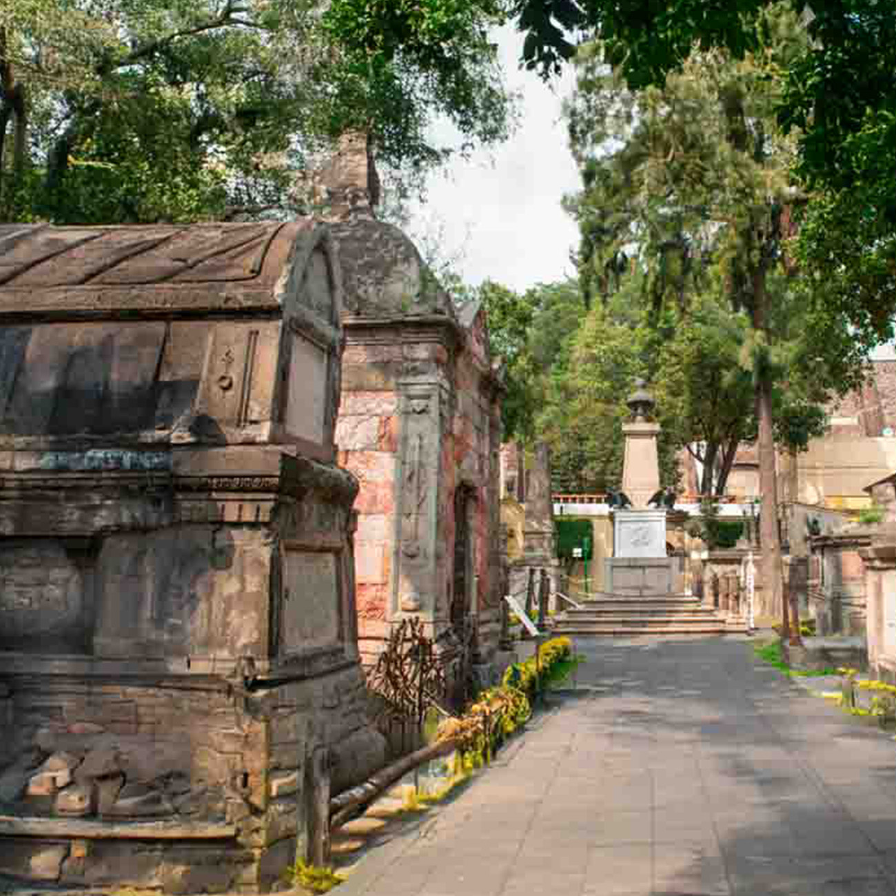 Cementerio de México con estructuras de piedra y rodeado de naturaleza.