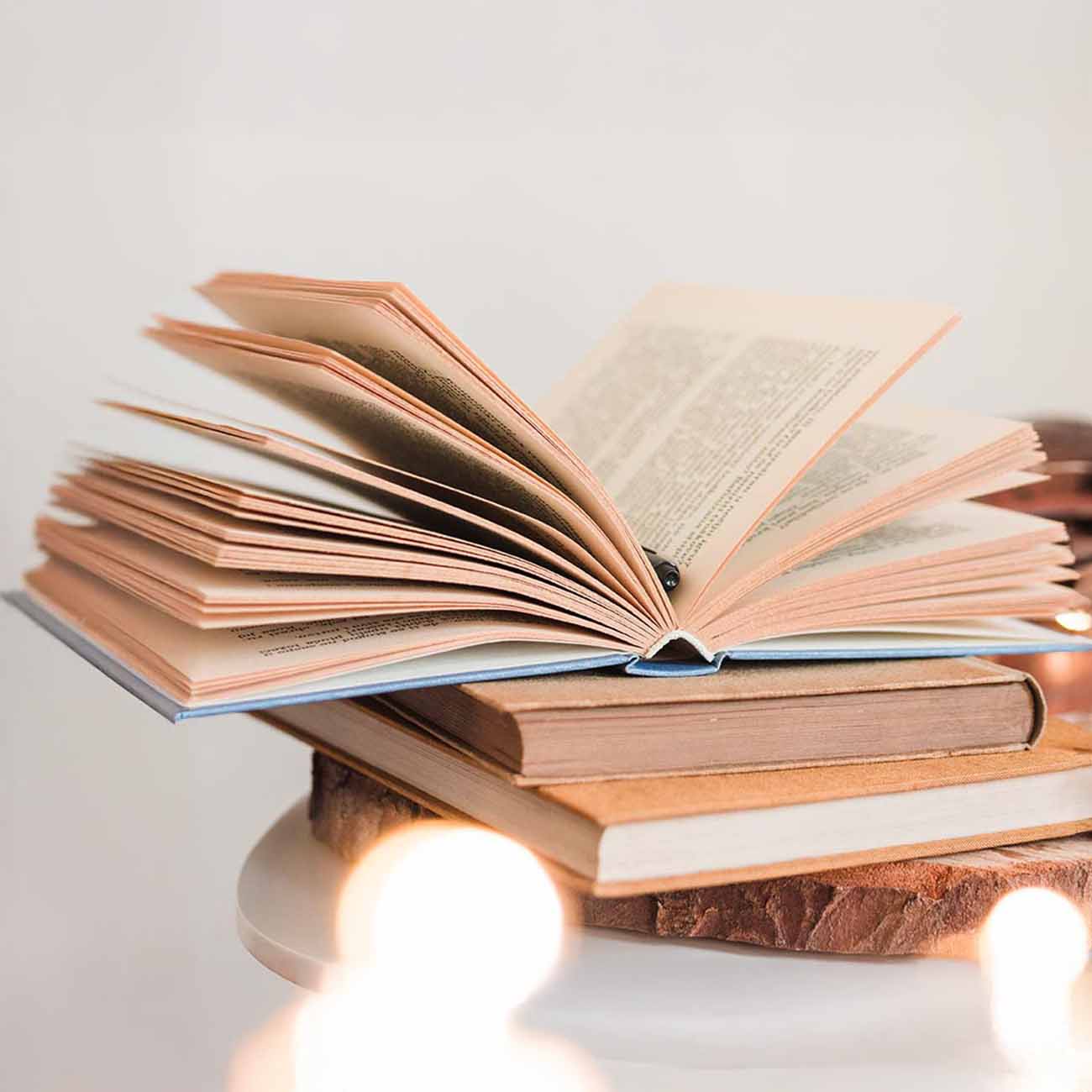 Libros apaliados sobre un pedazo de madera de forma circular.