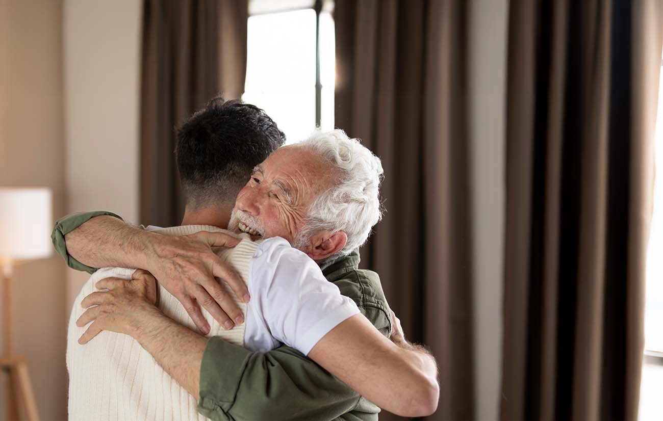 Nieto abrazando a su abuelo, se ven muy felices.