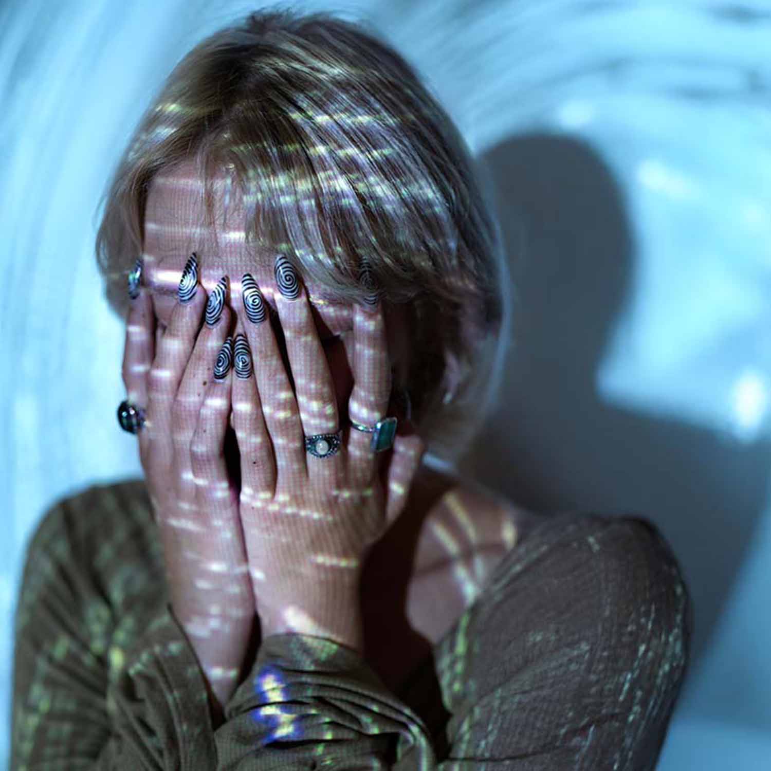 Mujer tapándose la cara expresando un profundo sentimiento de miedo.